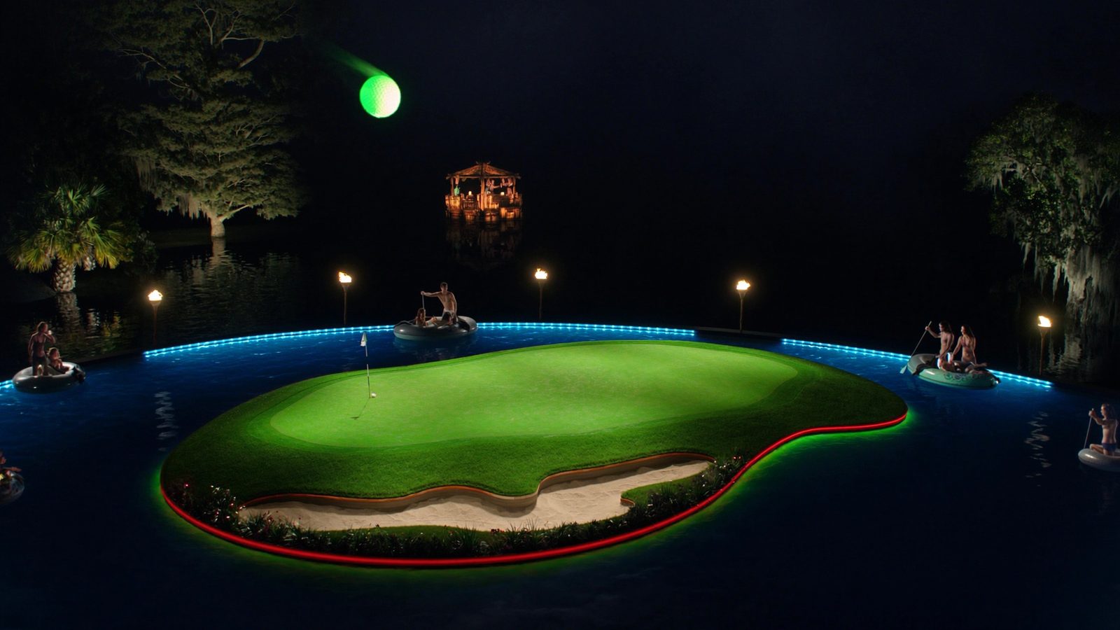 An island green glowing over dark water at night